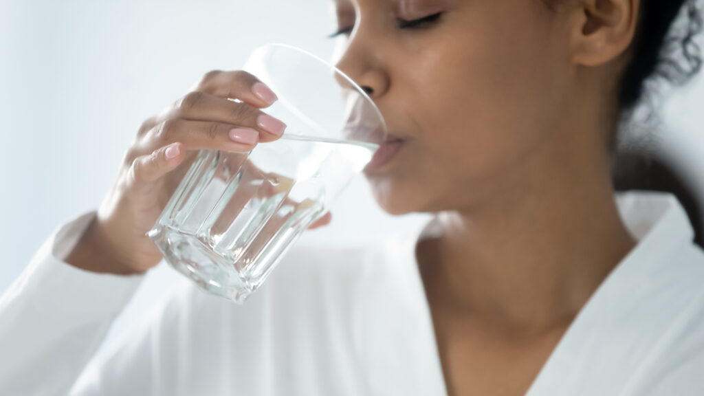 Woman drinking a glass of tap water