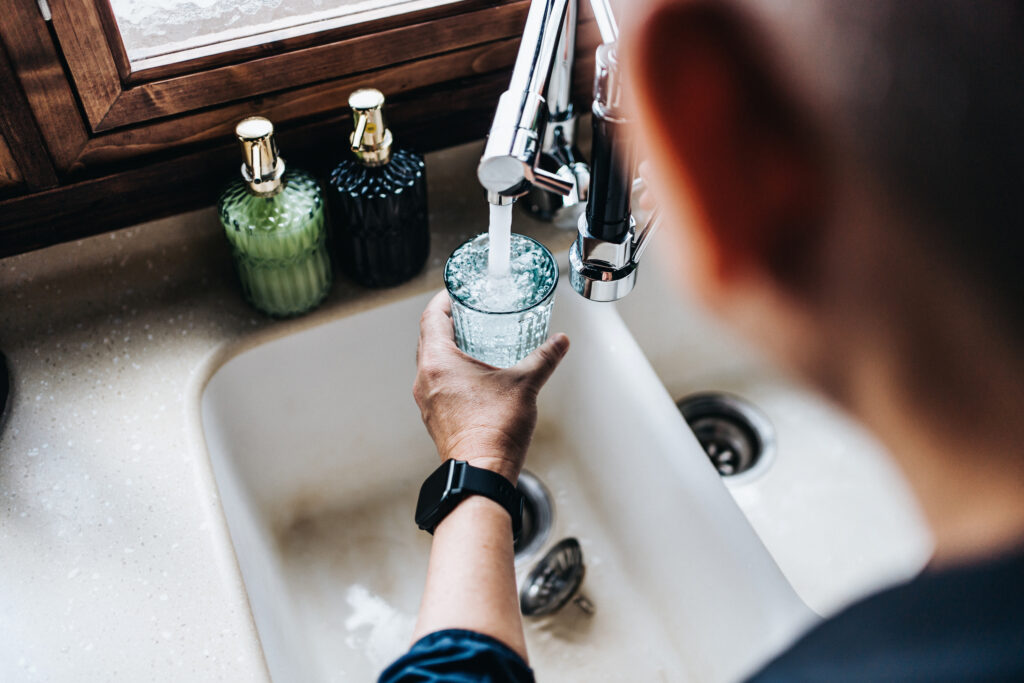 Over the shoulder view of man filling a glass